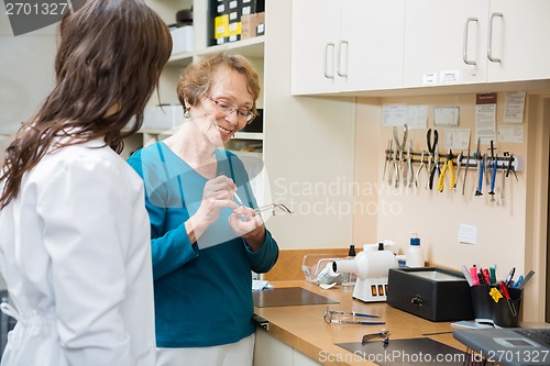 Image of Optician With Female Apprentice Repairing Glasses