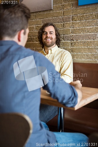 Image of Man With Friend Sitting At Coffeeshop