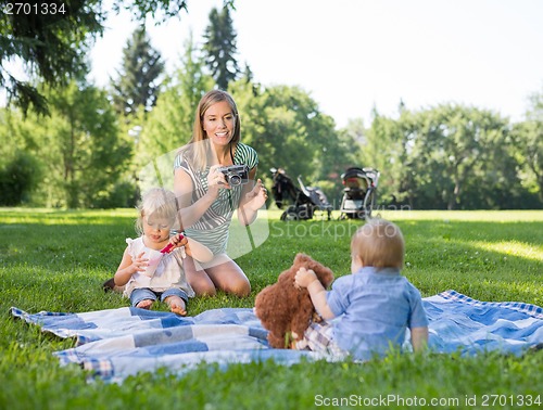 Image of Mother Photographing Children In Park