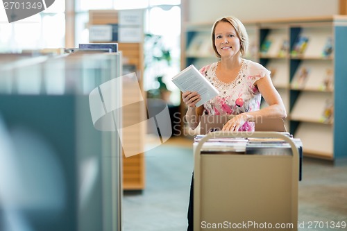 Image of Librarian With Trolley Of Books In Library