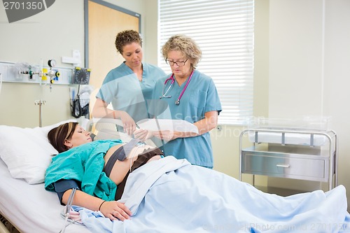 Image of Nurses Inspecting Fetal Monitor Report