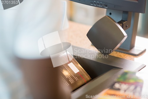 Image of Librarian Scanning Books At Library Counter