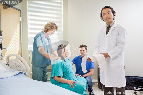 Image of Doctor Explaining Fetal Heartbeat Report To Pregnant Woman In Ho