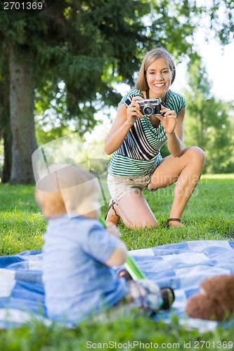 Image of Woman Clicking Picture Of Baby Boy In Park