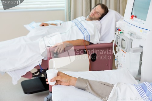 Image of Patient Holding Glass Of Crushed Ice During Dialysis