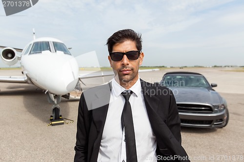 Image of Entrepreneur In Front Of Car And Private Jet