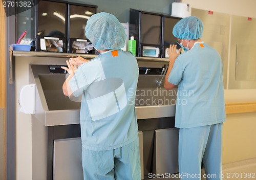 Image of Surgeons Washing Hands At Washbasin