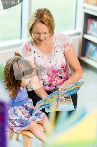 Image of Teacher With Schoolgirl Reading Book