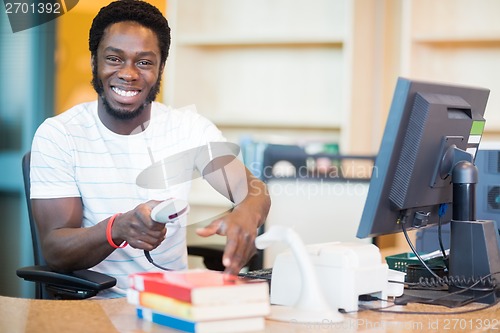 Image of Happy Librarian Scanning Books In Library