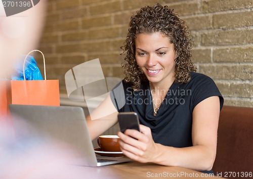 Image of Woman Using Cell Phone in Cafe