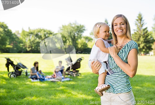 Image of Happy Mother Carrying Daughter In Park