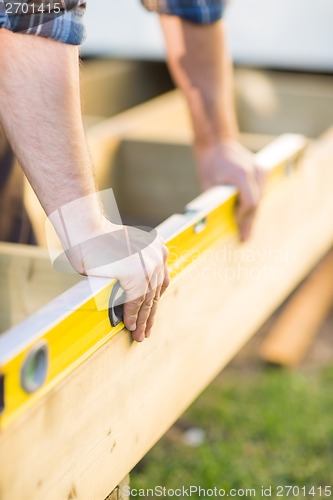 Image of Carpenter's Hands Checking Level Of Wood