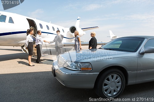 Image of Business Professional Greeting Airhostess And Pilot