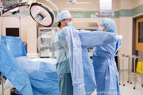 Image of Scrub Nurse Putting Sterile Gown on Surgeon