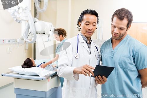 Image of Medical Team With Digital Tablet In Examination Room