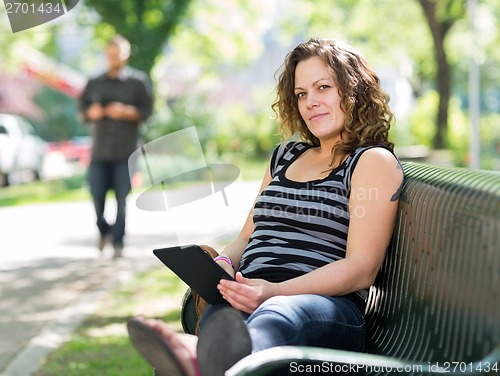 Image of Student Relaxing On Bench At University Campus