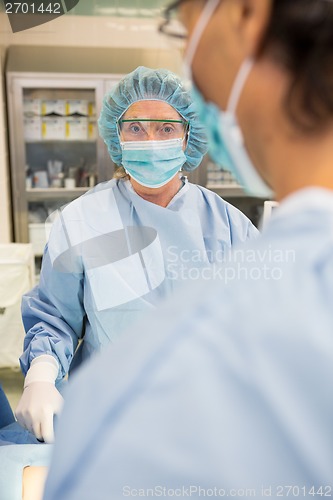 Image of Doctor With Colleague Operating Patient