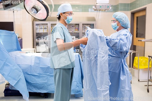 Image of Scrub Nurse Assisting Surgeon with Gown