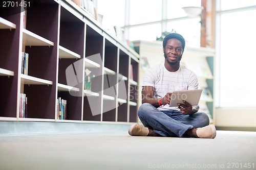 Image of Male Student Using Digital Tablet In Library