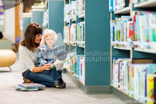 Image of Boy With Teacher Reading Book In Library