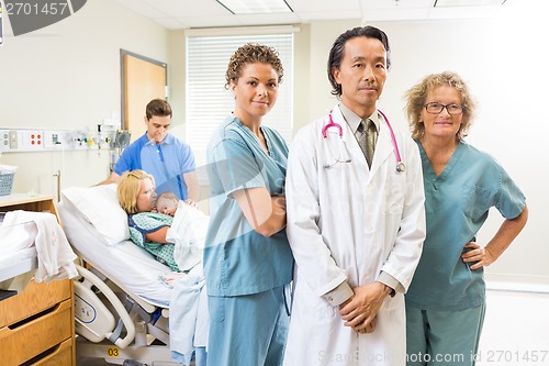 Image of Successful Medical Team With Newborn Baby And Parents In Backgro