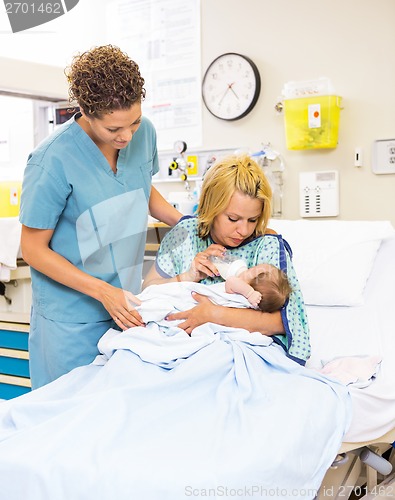 Image of Nurse Looking At Patient Feeding Milk To Baby At Hospital