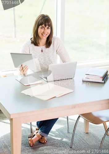 Image of Student Using Digital Tablet And Laptop In Library