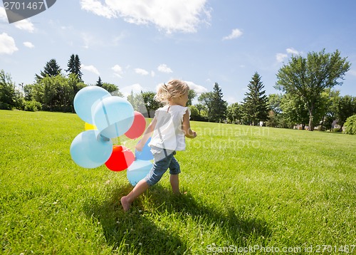 Image of Girl With Balloons Running In Meadow