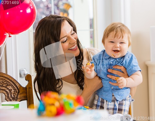 Image of Mother Holding Baby Boy At Birthday Party