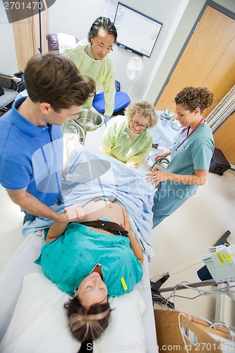 Image of Man Holding Woman's Hand During Delivery In Hospital