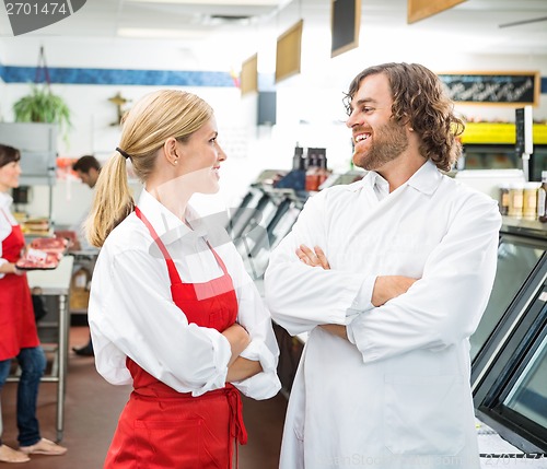 Image of Happy Butchers Looking At Each Other In Store