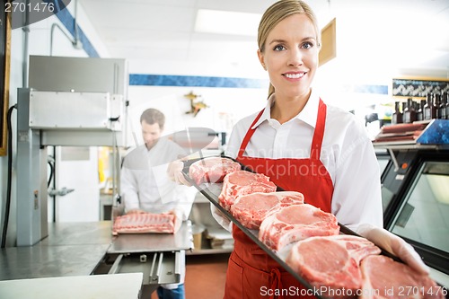 Image of Happy Butcher Showing Meat Tray In Store