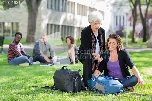 Image of Female University Students Using Digital Tablet On Campus