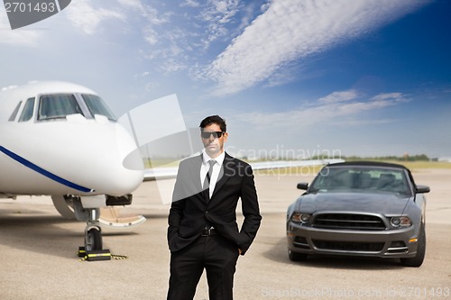 Image of Entrepreneur Standing In Front Of Car And Private Jet