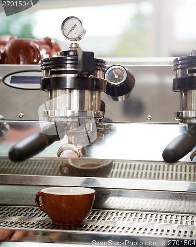 Image of Cup Under Portafilter Attached To Coffee Machine