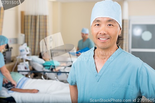 Image of Smiling Male Nurse Standing In Hospital Ward