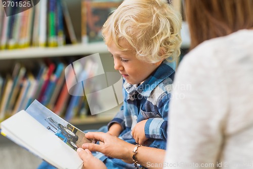 Image of Boy With Teacher Looking At Book In Library