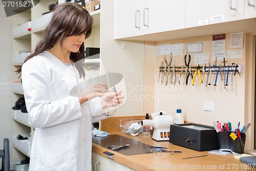 Image of Optician Repairing Glasses In Workshop