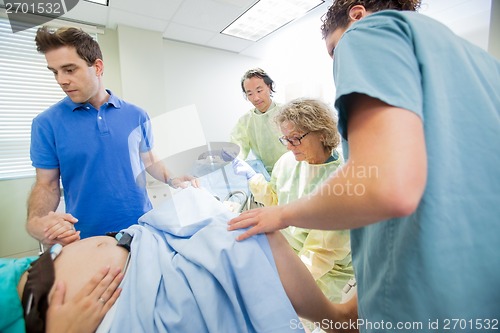 Image of Medical Team Examining Pregnant Woman During Delivery In Operati