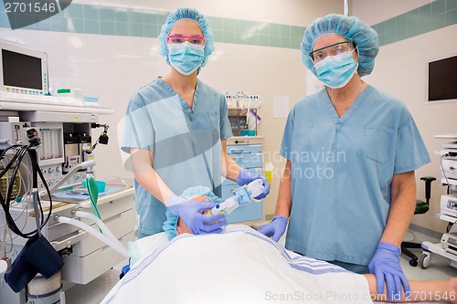 Image of Nurses Adjusting Oxygen Mask On Female Patient
