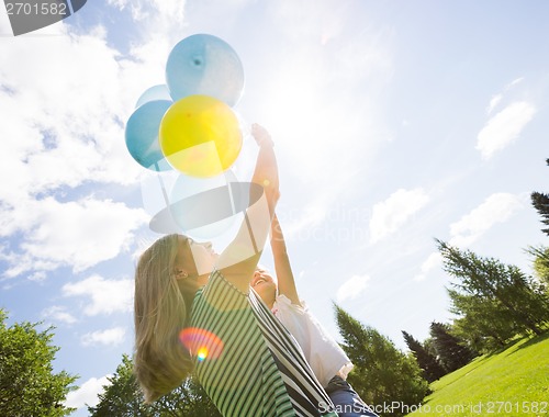 Image of Mother And Daughter Playing With Balloons In Park