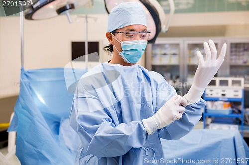 Image of Surgeon Wearing Surgical Gloves In Operation Room