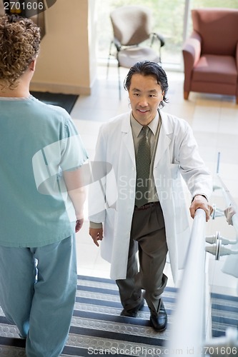 Image of Doctor Climbing While Nurse Walking Down Stairs In Hospital