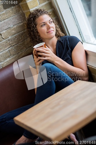 Image of Woman Looking Through Window In Cafeteria