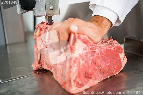 Image of Hand Slicing Meat On Bandsaw