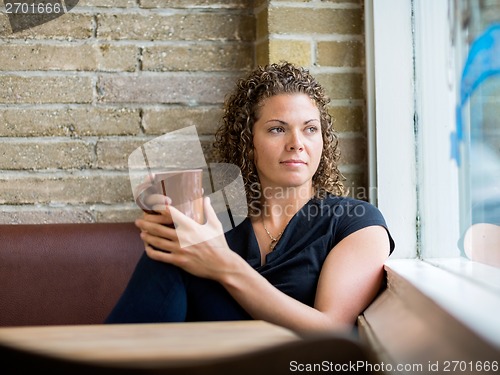 Image of Woman Looking Through Window At Cafeteria