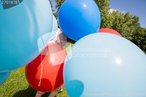 Image of Boy Holding Balloons In Park