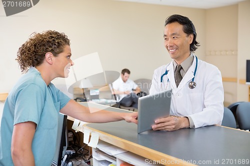 Image of Doctor And Nurse Using Digital Tablet At Hospital Reception