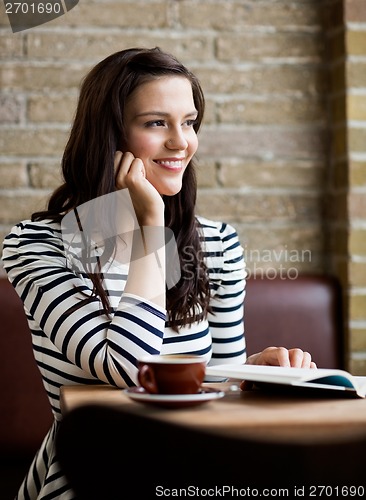 Image of Woman With Hand On Chin Looking Away In Cafeteria
