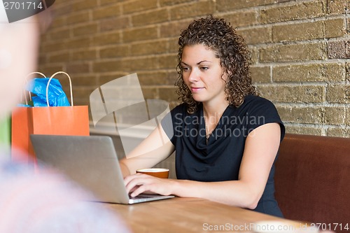 Image of Woman Using Laptop At Table In Cafeteria